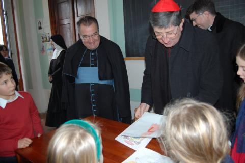 Le Cardinal apprécie les dessins que les enfants lui offrent